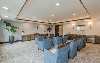 a lobby with blue chairs and a counter in the middle of a room